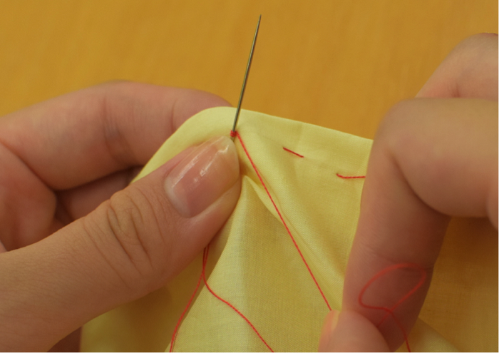 1.縫い終わりの位置に針を置き、針に糸を2回ほど巻きます。