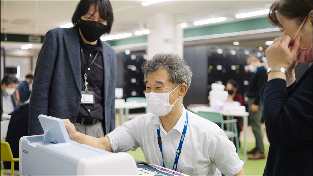 スキャンカットを使う男性と説明する女性たち