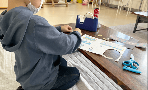 ペーパークラフトをカットする少年