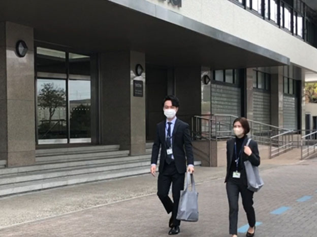 エコバッグを持って取引先へ向かう従業員