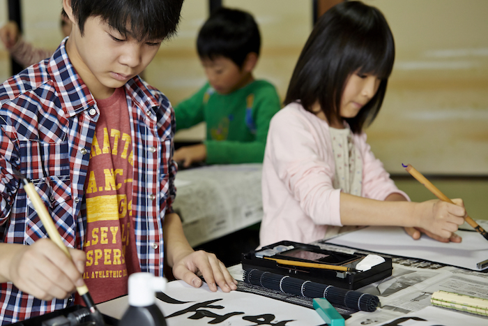 真剣に習字をするお子様