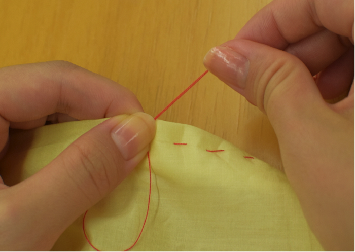 2.1で巻いた部分を、針を持っていない手の親指でしっかりと押さえ、そのまま針を引き抜きます。