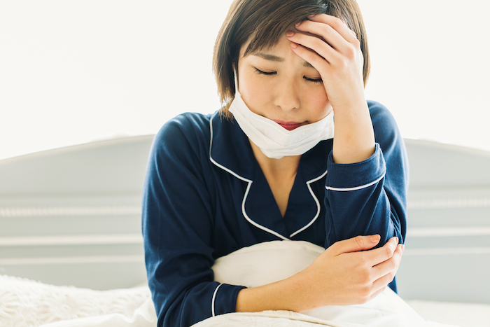 体調を崩している女性の写真