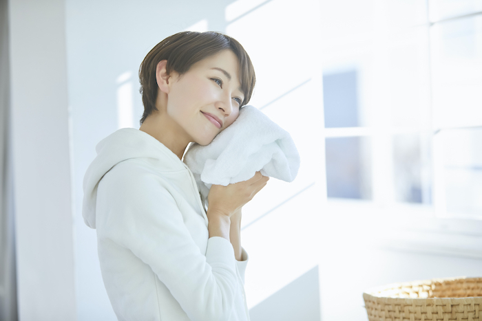 洗濯したタオルを持っている女性の写真