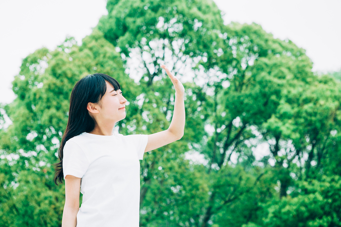 日差しを気にしている女性の写真