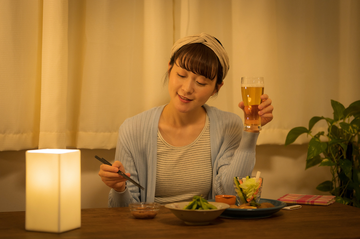 料理とともにお酒を楽しむ女性の写真