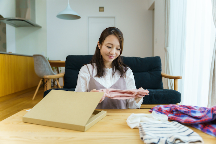 服を梱包している女性の写真