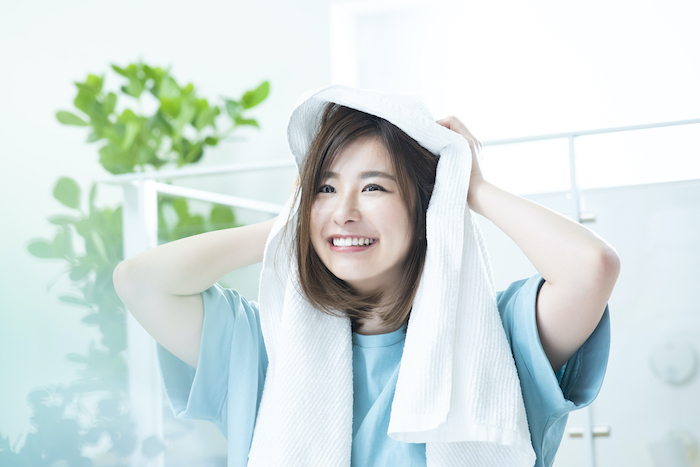 タオルで髪を拭く女性の写真