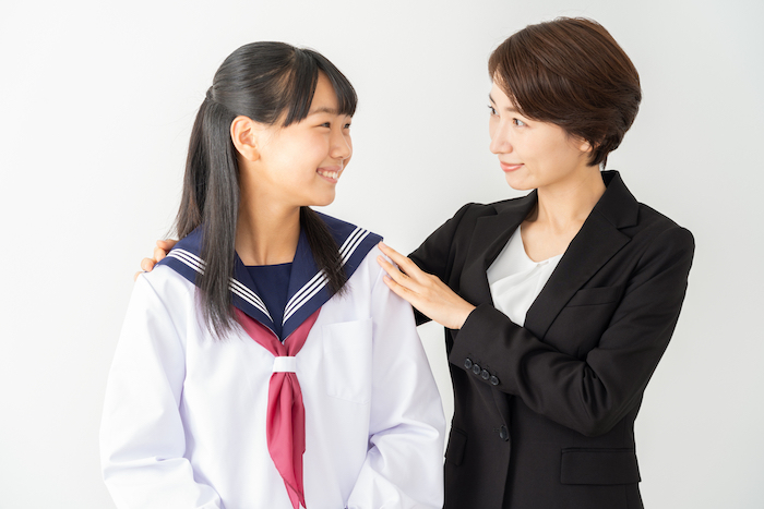 制服姿の娘を励ます母親