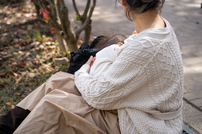 公園で授乳ケープを使う女性