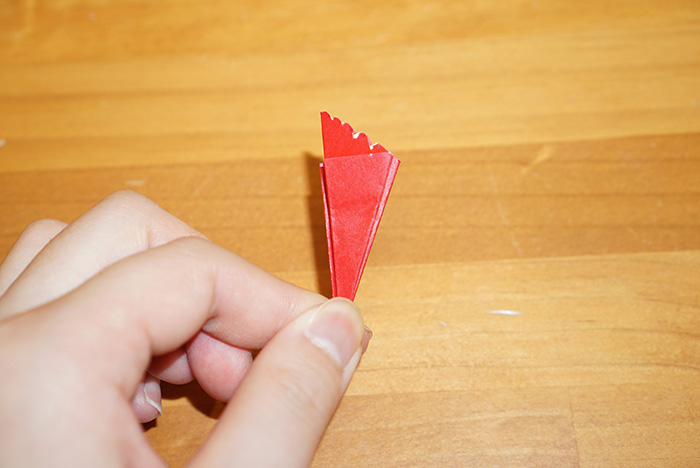 縦に折り目が入るように真ん中で半分に折り、口の部分をギザギザにカットしていきます。最初にえんぴつなどで下書きしておくと切りやすいです。