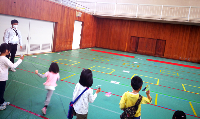 完成した紙ヒコーキを飛ばすお子様