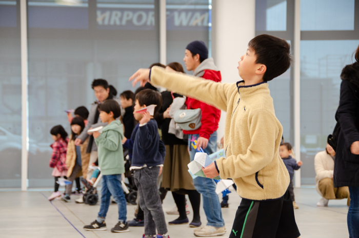 完成した紙飛行を飛ばす子どもたち