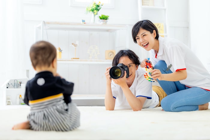 写真を撮られている子供とカメラを向ける大人たち