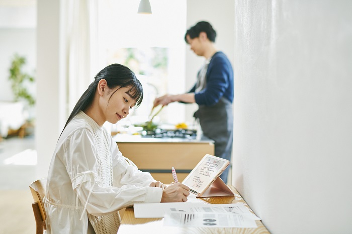 料理をする男性と勉強する少女