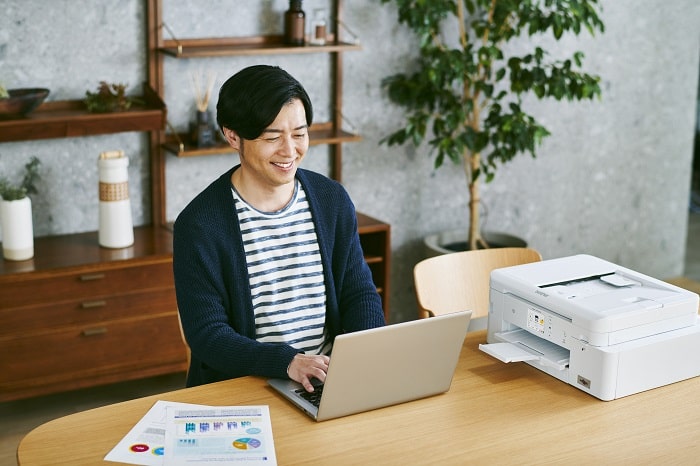 在宅ワークをする男性とプリンター