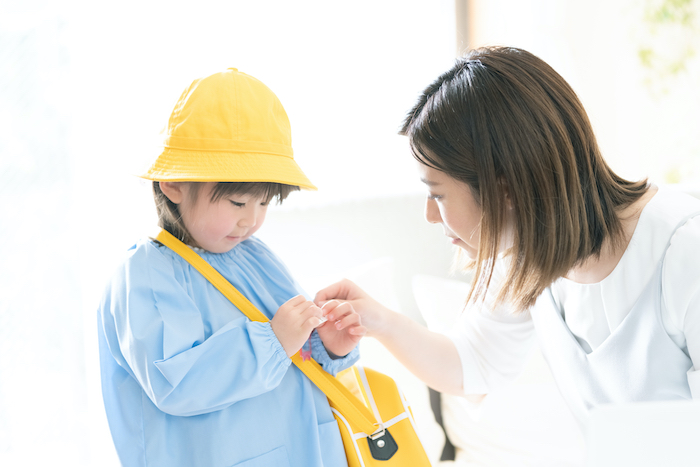 お出かけの準備をする子どもと母親