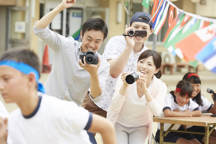 運動会で子供の写真を撮る親たち